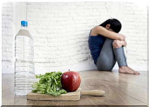 Sad woman refuses to eat salad and drink water