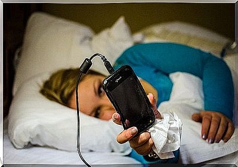 Woman lying with a phone - the pain from carpal tunnel syndrome