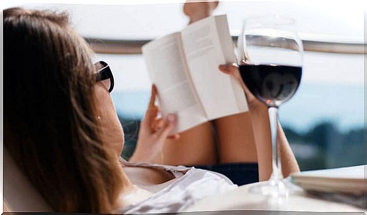 Woman reading book with red wine