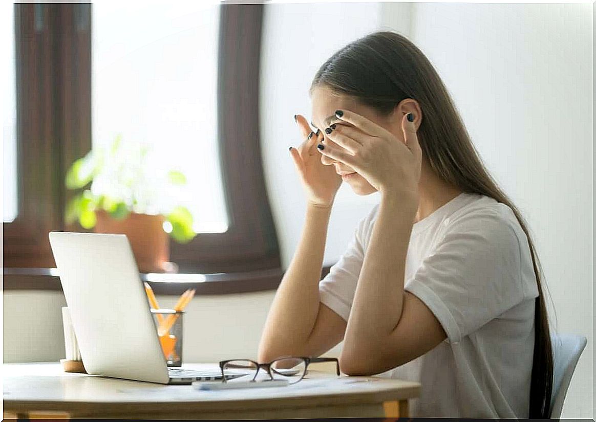 Woman with headache takes care of eyes