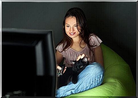 woman watching television with her cat