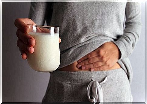 Woman with stomach ache and a glass of milk