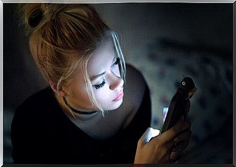 Woman looking at phone in the dark