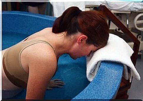 Woman in feeding vessel for water birth