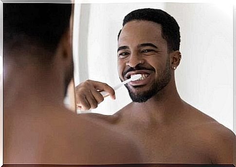 Man brushes teeth with toothpaste with fluoride