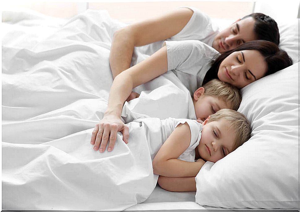 A family sleeping in bed