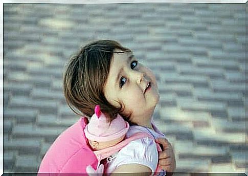 Girl carrying doll on back