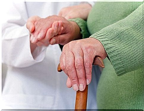 Elderly person with a cane is with the doctor