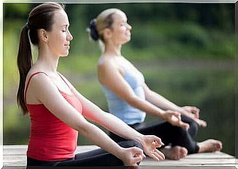 Women practice yoga outside