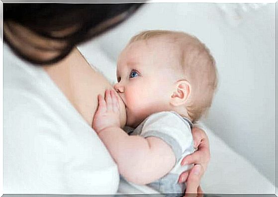 Baby breastfeeds with her mother