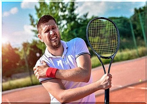 Man playing tennis takes care of shoulder